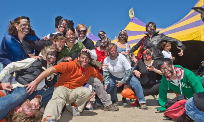 Photo of a group of people outside posing together with faces painted.